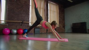 İnce, sportif, formda kadın içeride yoga egzersizi yapıyor.