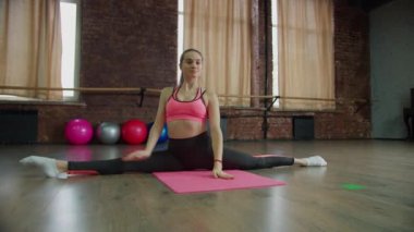 Slim sportif fitness kadını spor salonunda ön tarafta ayrılıyor.