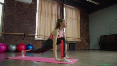 Formda bir kadın içeride yüksek atlama egzersizi yapıyor.