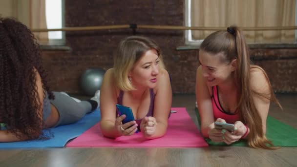 Mulheres desportivas com telefones relaxante após o treinamento — Vídeo de Stock
