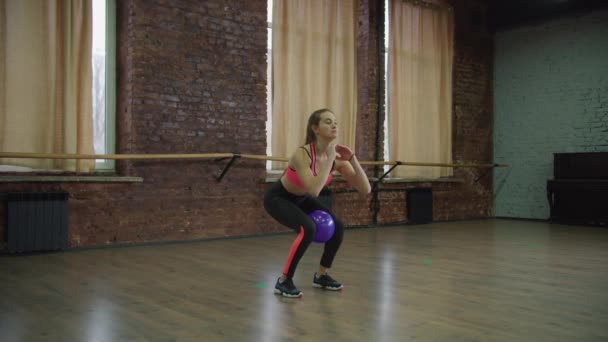 Passform kvinna gör knäböj med medicin boll på gym — Stockvideo
