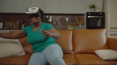 Evde oynanan VR oyun tecrübesiyle sersemlemiş olgun bir kadın.