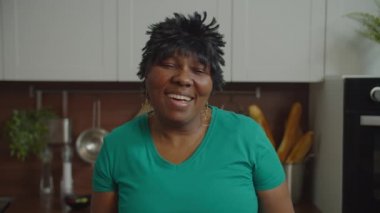 Oldukça kıdemli Afro-Amerikan kadın içerde gülümsüyor.