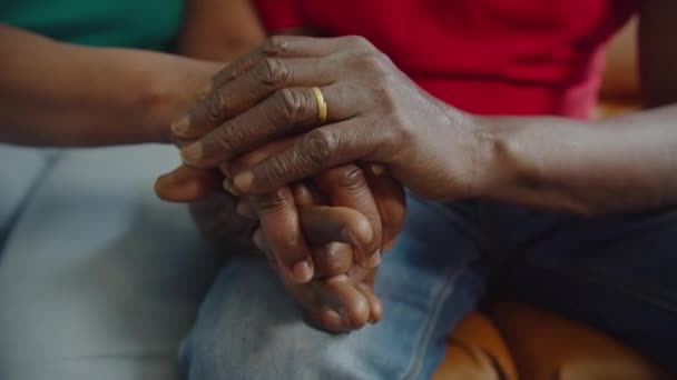 Крупный план пожилой черной пары, держащейся за руки — стоковое видео