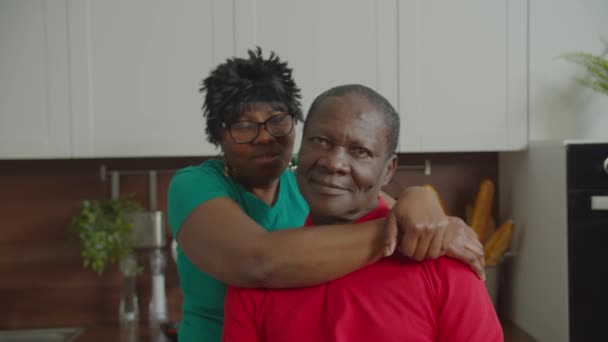 Любящие черные пары обнимаются на домашней кухне — стоковое видео
