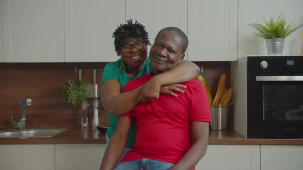 Mature african couple hugging in domestic kitchen — Stock Video