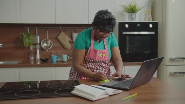 Mujer africana madura en busca de recetas en línea — Vídeos de Stock