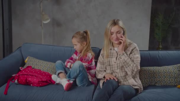 Занята телефоном мать игнорирует расстроенную девушку в помещении — стоковое видео