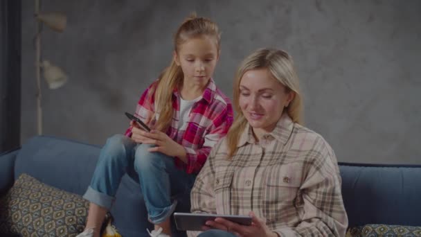 Anya és lánya otthon hálózatba kötik a kütyüket — Stock videók