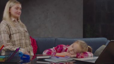 Umursayan anne evde uyuyan kızı uyandırıyor.