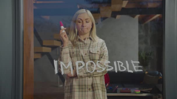 Woman changing word impossible into possible on glass — Stock Video