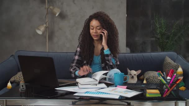 Multitasking gemengde ras vrouw werken in het thuiskantoor — Stockvideo