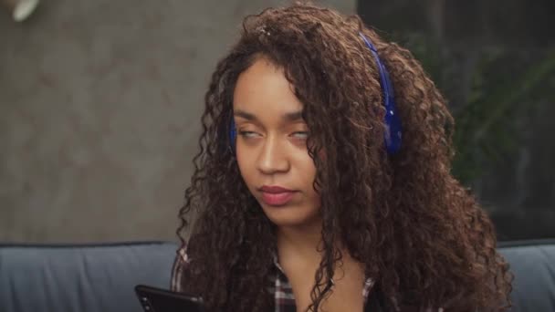 ヘッドフォンで音楽を聴くケアフリー女性 — ストック動画