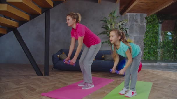 Keluarga fit aktif melakukan membungkuk di atas baris dumbbell di dalam ruangan — Stok Video