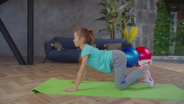 Sportieve fit pre-adolescent meisje uitvoeren van ezel kick oefening — Stockvideo