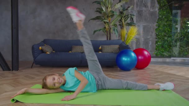 Menina flexível bonito exercitar elevador perna lateral em casa — Vídeo de Stock