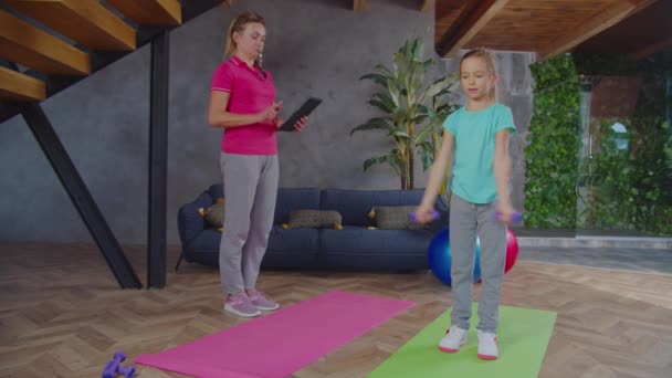 Фітнес мати відстеження тренування рутини дочки — стокове відео