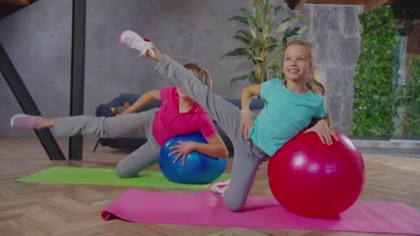 Ajuste el ejercicio femenino y del niño con la bola de la aptitud — Vídeos de Stock