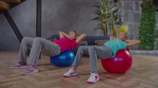 Actieve sportieve fit familie doen sit-ups op Zwitserse ballen — Stockvideo