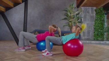 Anne ve çocuk denge topu üzerinde mekik çekiyorlar.