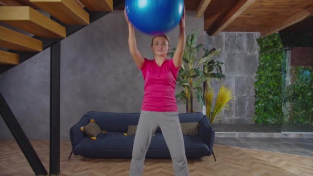 室内で安定したボールでスクワットスポーティフィット女性 — ストック動画