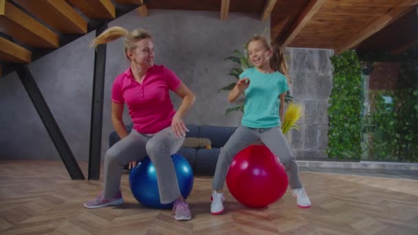 Feliz mamá y el niño retozando en las bolas de fitness — Vídeos de Stock