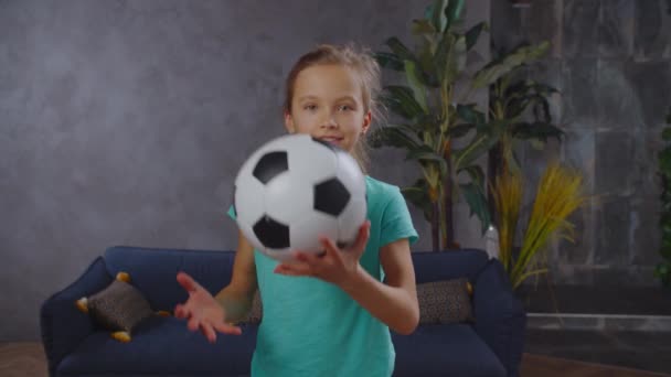 Schöne kleine Mädchen posiert mit Fußball in der Halle — Stockvideo