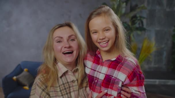 Хорошенькая позитивная мама и маленькая девочка смеются в помещении — стоковое видео