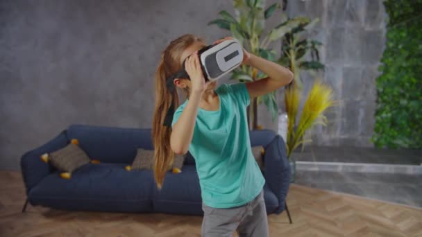 가상 현실 헤드셋으로 비디오 게임을 하는 어린 소녀 — 비디오