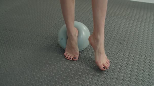 Detailní záběr bosých ženských nohou cvičení na medicínské kouli — Stock video