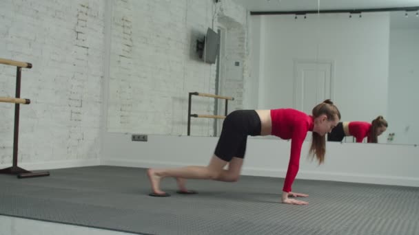 Adatto donna che fa asciugamano ginocchio tavola in esercizio in palestra — Video Stock