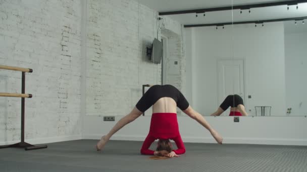 Bakifrån av sportig passform kvinna gör yoga headstand — Stockvideo