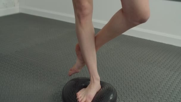 Спортивная женщина, занимающаяся йогой, позирует на подушке равновесия — стоковое видео