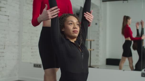 Персональный тренер, помогающий женщине на растяжке тела — стоковое видео