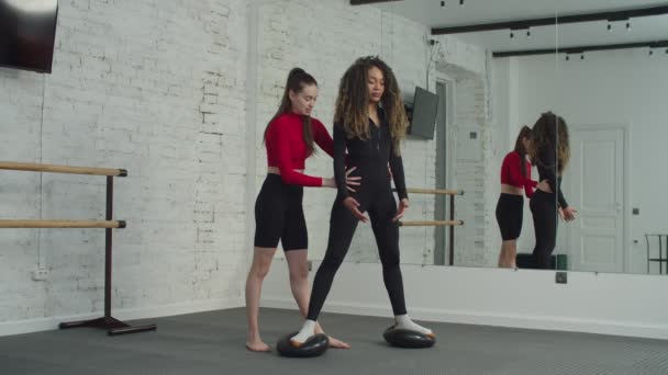 Fitness trainer helpen vrouw om crossover squat doen — Stockvideo