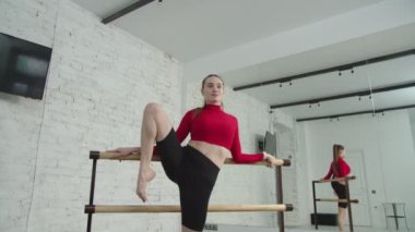 Sportif formda bir kadın spor salonunda ayakta duruyor..