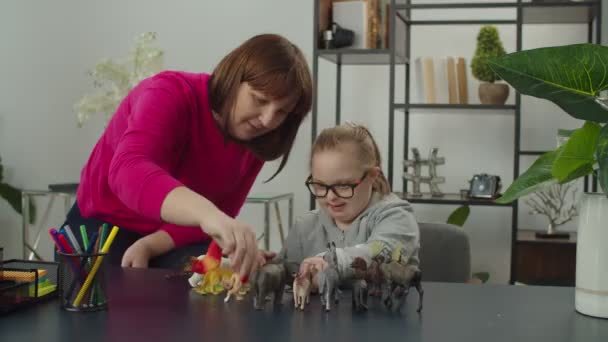 Mutter mit Down-Syndrom-Kind in pädagogischem Spiel engagiert