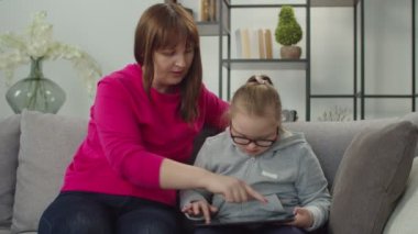 Güzel Down sendromlu kız. Annesiyle tablet bilgisayarında iletişim kuruyor.