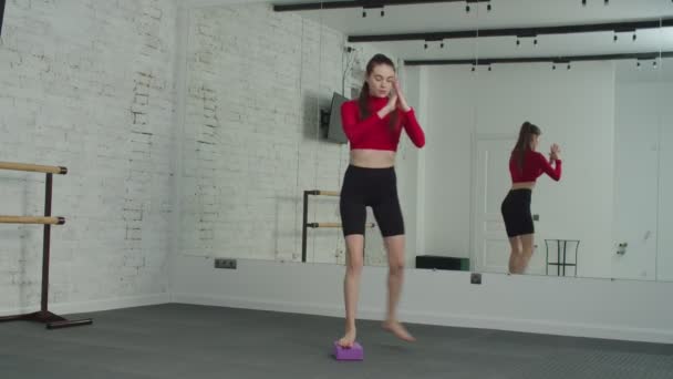 Fit vrouwelijke oefening curtsy lunge in fitness club. — Stockvideo