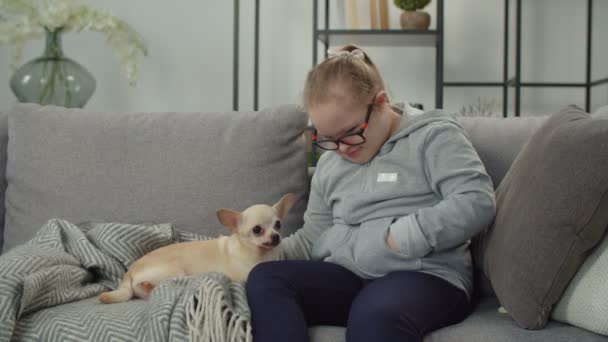 Özürlü bir kız. Chihuahua köpeğini besliyor. — Stok video