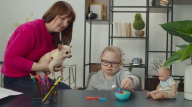 Annesiyle evde matematik öğrenen özel ihtiyaçları olan bir kız.