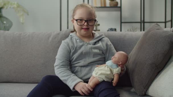 Šťastná rozkošná dívka s Downovým syndromem hrát s panenkou — Stock video