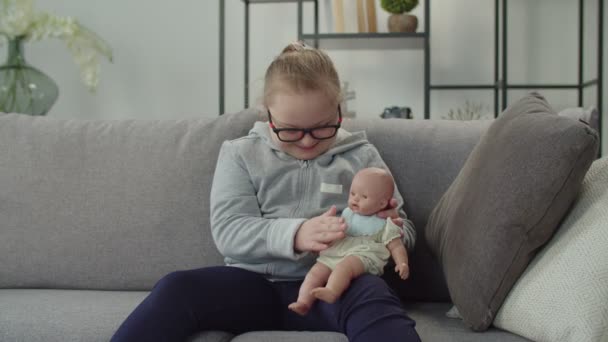 Nettes Mädchen mit genetischer Krankheit spielt mit Puppe — Stockvideo