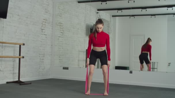 Sportif kadın spor salonunda direniş bandıyla egzersiz yapıyor. — Stok video