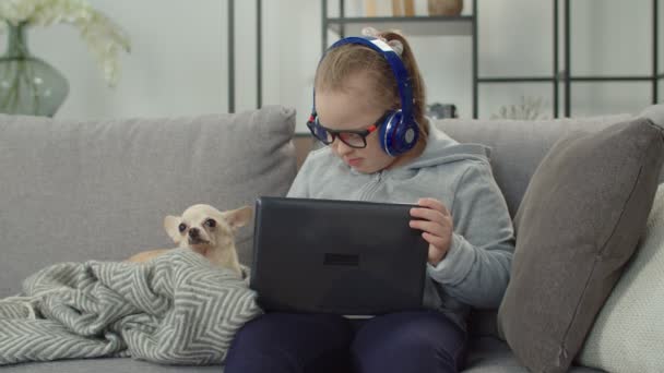Criança necessidade especial com cão assistindo desenhos animados on-line — Vídeo de Stock