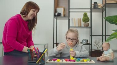 Annesiyle evde sabun köpüğü üfleyen sevimli bir çocuk.