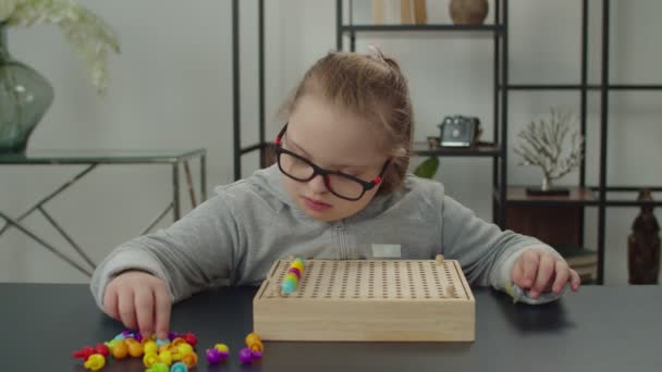 Liebenswerte Mädchen mit besonderen Bedürfnissen spielen mit Sortierpuzzle-Spielzeug — Stockvideo