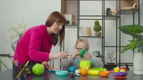 Mamá con hija discapacitada jugando juego de juguete de cocina — Vídeo de stock