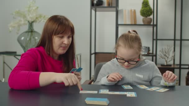 Down sendromlu kız ve annesi eğitim oyunu oynuyorlar. — Stok video