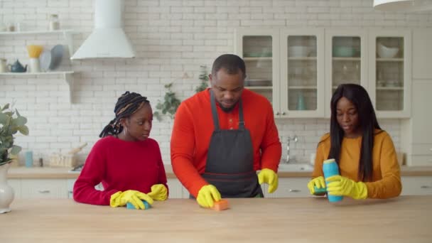 Padre africano e hijas limpiando mesa de cocina — Vídeo de stock